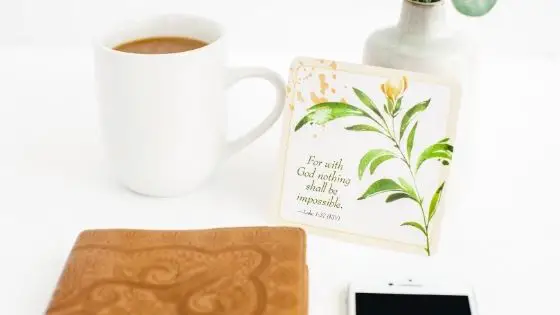 Coffee mug next to Bible and Scripture card