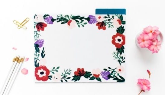 Desk with floral paper, stationery and flowers