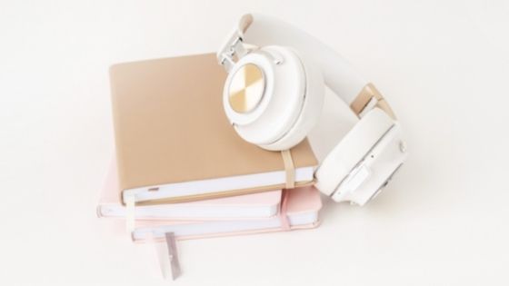 White headphones on top of a set of books