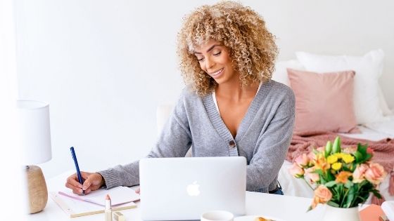 Woman writing in notebook smiling overcoming fear in life
