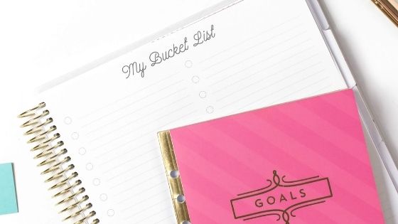 Pink Goals Notebook on top of blank bucket list page