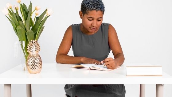 African American girl sitting and writing in her notebook at a desk