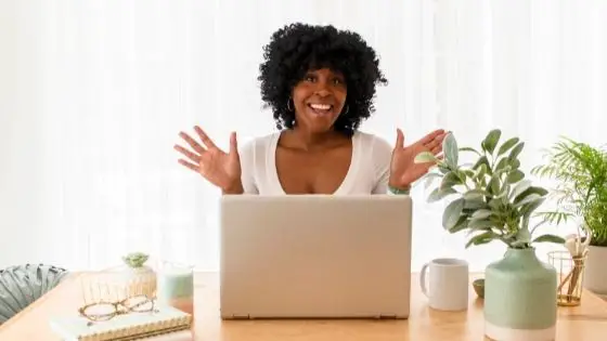 Happy African American girl in front of desk with laptop
