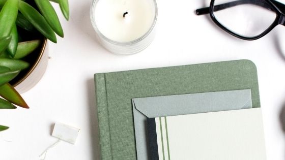 Books, glasses, candle and flower pot on a table