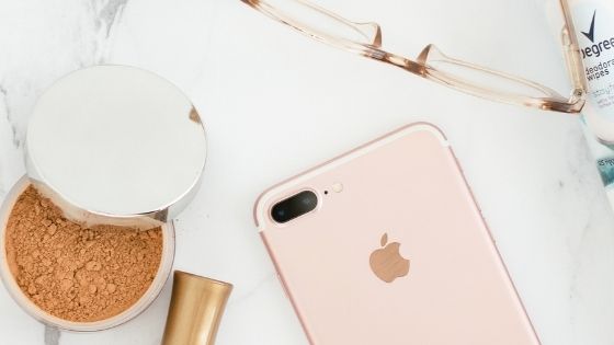 I-Phone next to make-up and glasses