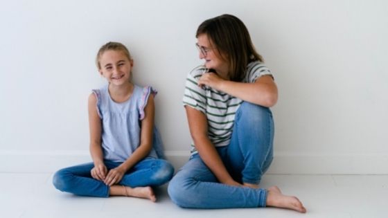 Mom and daughter sitting together talking and laughing