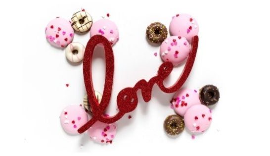 The letters love on top of sweet doughnuts and cookies