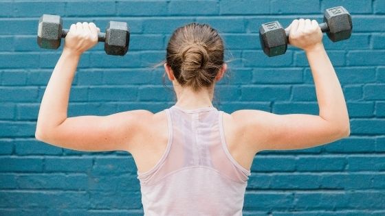 Woman exercising holding two dumbbells