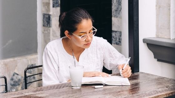 Girl sitting writing in her notebook